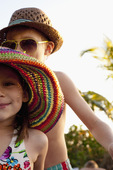 裁剪的女孩和弟弟的肖像戴着太阳帽在海滩上，萨尼贝尔，佛罗里达，美国图片素材