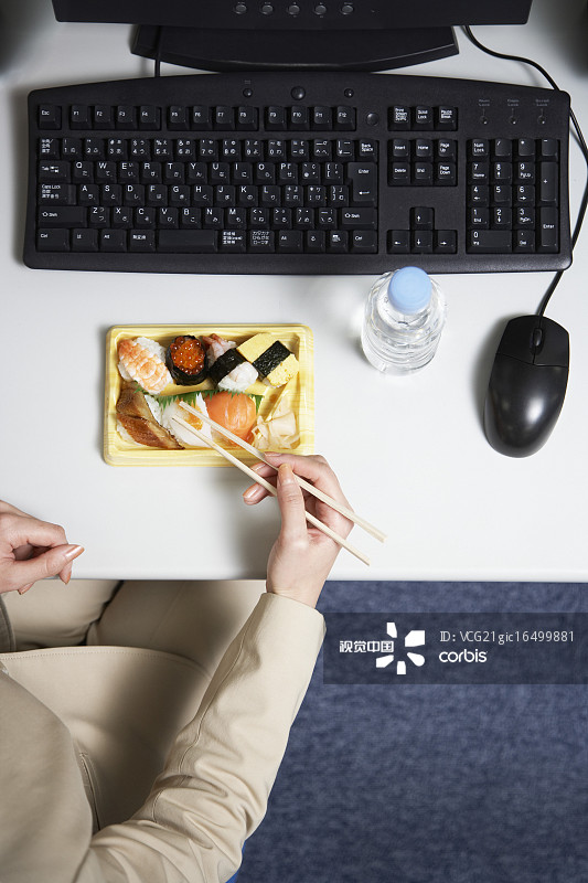 女商人在辦公桌上吃壽司圖片素材