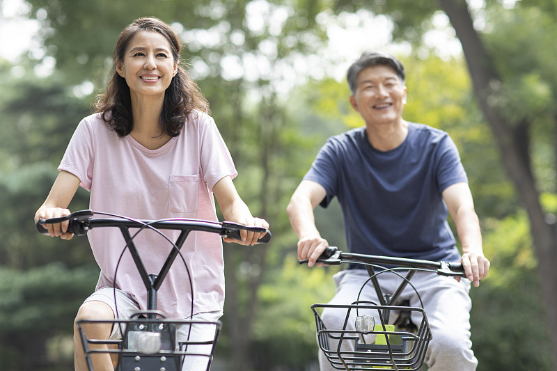 快樂的成熟夫婦在公園騎自行車圖片素材