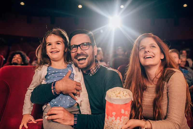 年輕女孩和她的家人在電影院圖片素材