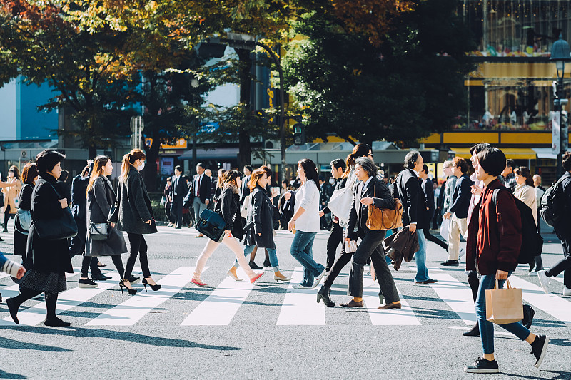 東京澀谷十字路口，一群忙碌的上班族正穿過馬路圖片下載