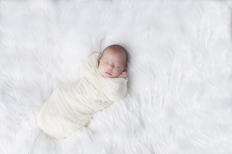 新生儿睡得很好，包裹着白色图片下载