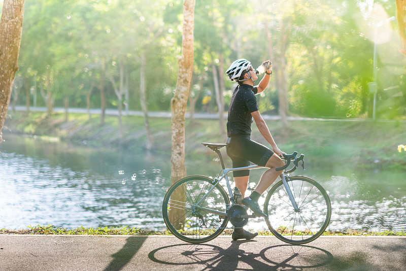 年輕的騎自行車的人在早上騎山地車在小徑上圖片素材