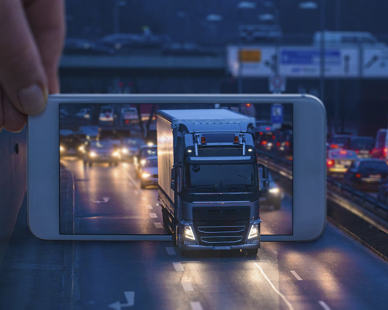 手機顯示一輛卡車通過手機行駛圖片素材