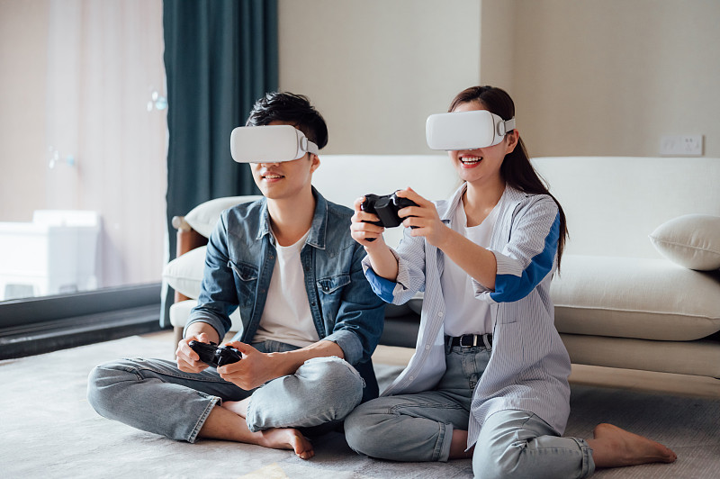 亞洲年輕情侶在家戴VR眼鏡打游戲圖片素材