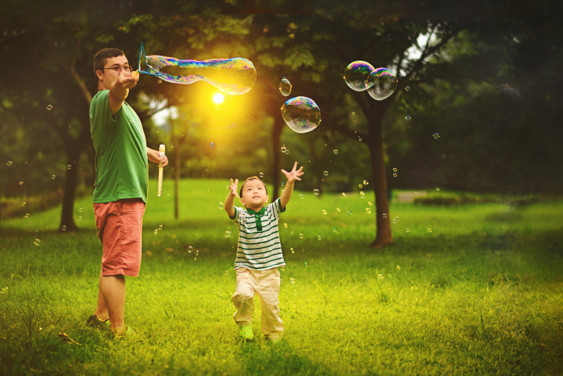 亞洲小孩和父親玩泡泡棒圖片下載