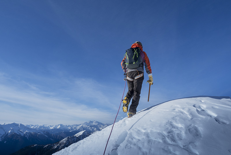 攀登者到達白雪皚皚的山頂圖片素材