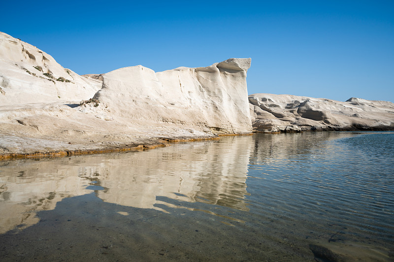 希臘米洛斯，海上倒映的白色巖石攝影圖片