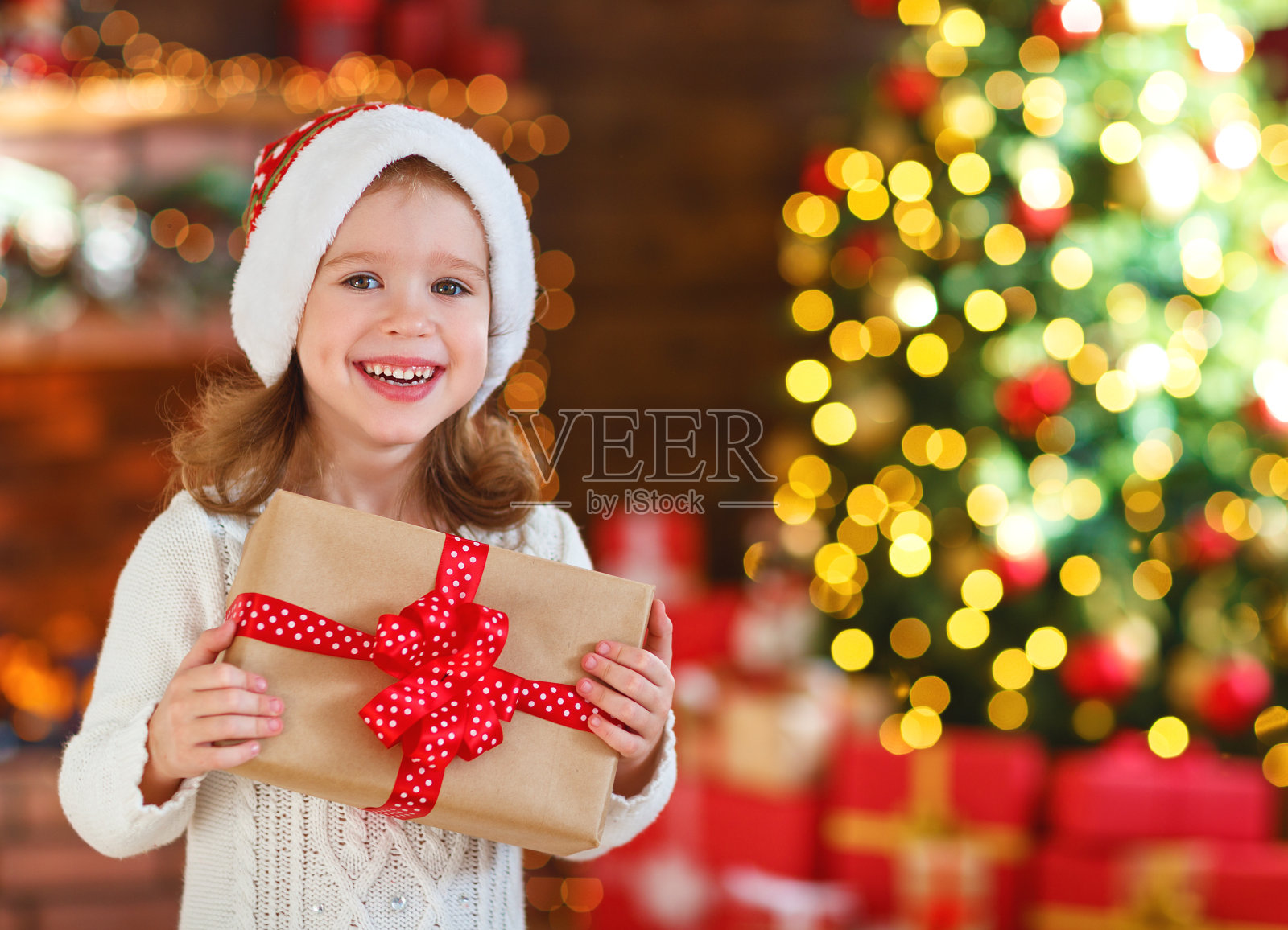 快樂歡笑的童女帶著圣誕禮物在家照片攝影圖片