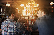 人，男人，休闲，友谊和交流的概念-亲密的快乐的男性朋友在酒吧或酒吧喝生啤酒图片素材