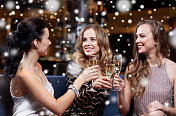 庆祝，朋友，单身派对和假日概念-快乐的女人与香槟杯在夜总会图片素材