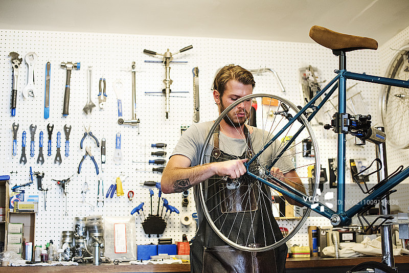 一个在自行车修理店工作的人。图片素材