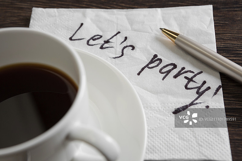写在餐巾上的信息。写在餐巾上的字和放在木桌上的咖啡杯图片素材