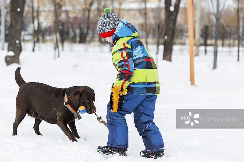 学龄儿童和狗在冬季公园。我最好的朋友和我图片素材