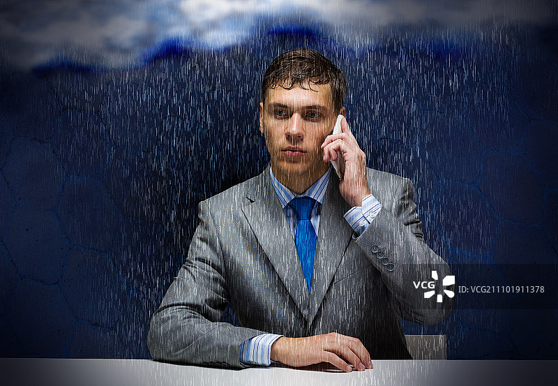 商业挑战。年轻失意的商人在雨中打电话图片素材