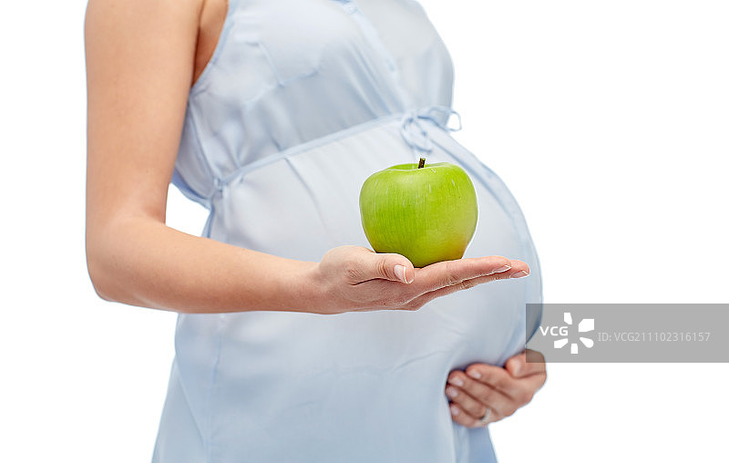 怀孕，健康饮食，食物和人的概念-近距离拍摄孕妇抱着绿苹果在白色的背景图片素材