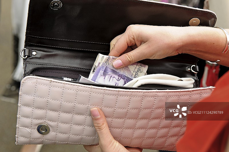 女人从钱包里取出钱的特写，伯克郡，伦敦，英国图片素材