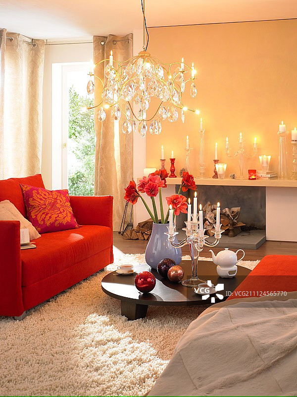 客厅有红色的沙发，毛皮地毯，点燃的蜡烛和枝形吊灯图片素材
