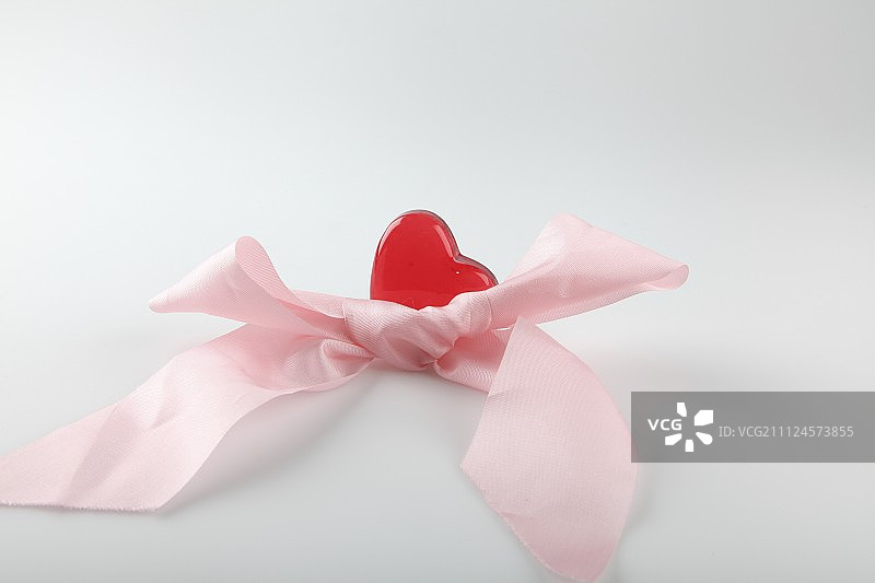 特写的粉红色丝带与心在白色的背景图片素材