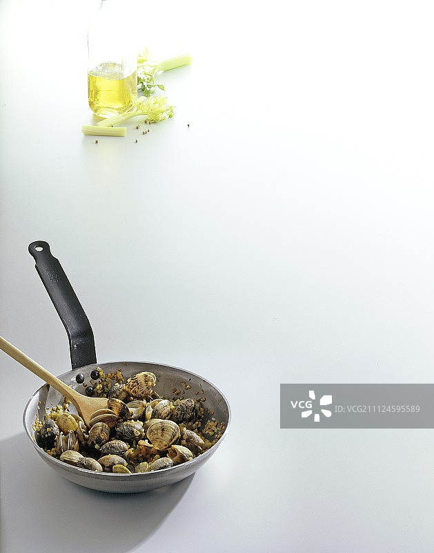 锅里的贻贝，芹菜和一瓶油在白色的背景上，复制空间图片素材