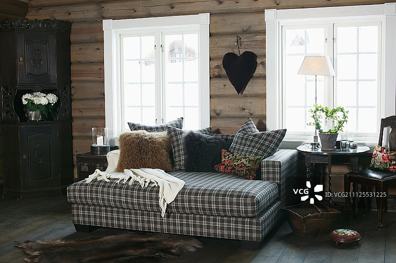 在木质房子里，格子窗和白色框架前的沙发床和配套的散垫图片素材