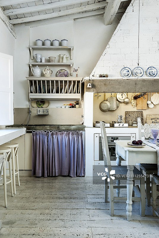 质朴的老式厨房，用餐区在炊具前面，下面是砖石抽油烟机罩图片素材