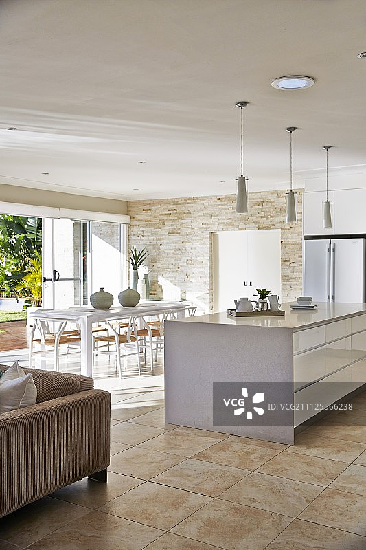 白色厨房岛与抽屉前用餐区在现代室内瓷砖地板图片素材