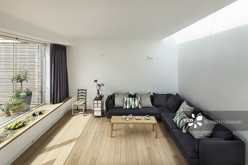 角落沙发与灰色内饰在极简主义的木地板和全景窗口集成窗座位图片素材
