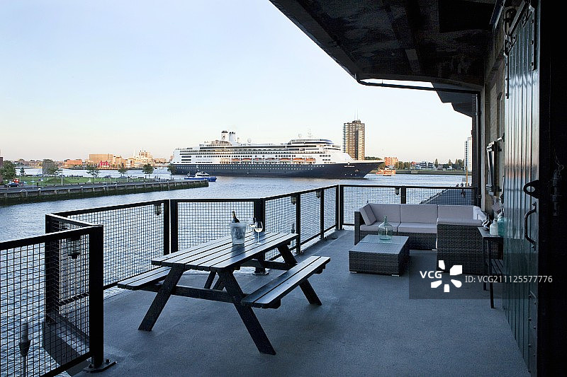 宽敞的阳台，结合户外家具和河上游船的景色图片素材