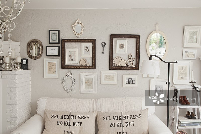 白色沙发，粗麻布散垫，墙上挂画和相框图片素材