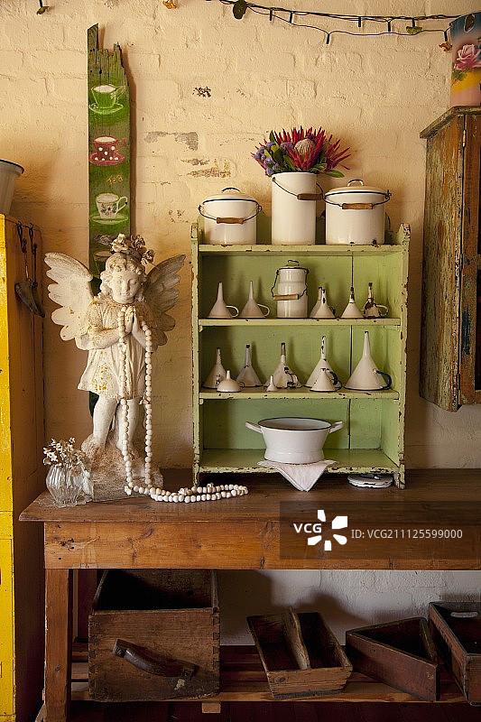 天使小雕像和小架子单元漆成绿色，在木桌上收集漏斗图片素材