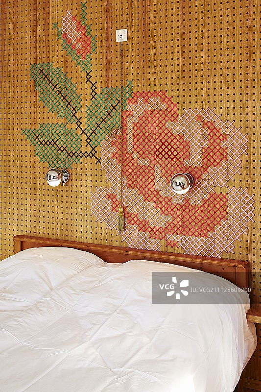 双人床靠十字绣绳纹花装饰的穿孔嵌板图片素材