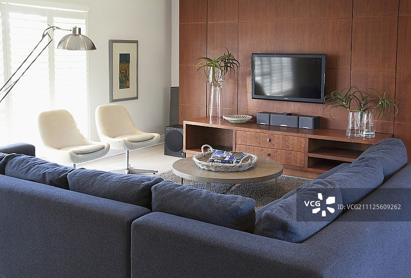 现代化的座位区设有角落沙发，转椅和优雅的木质媒体中心图片素材