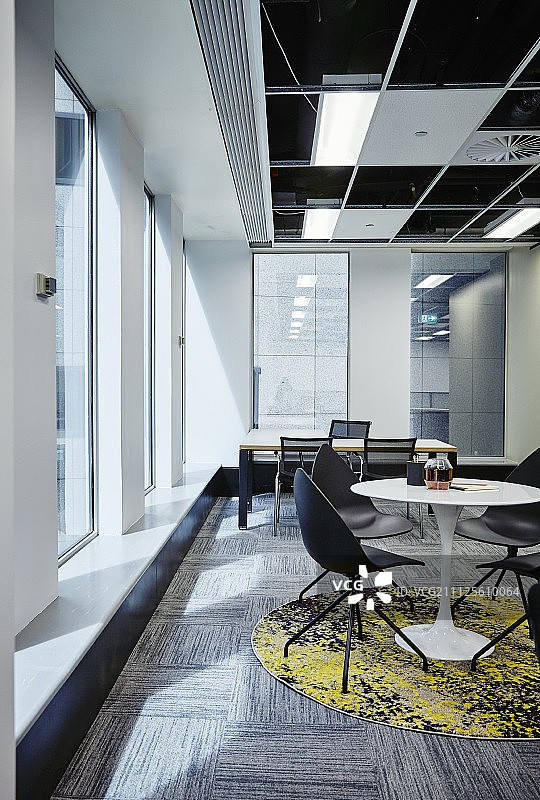 小型会议区，贝壳椅和郁金香桌在圆形地毯在办公桌前现代办公室图片素材