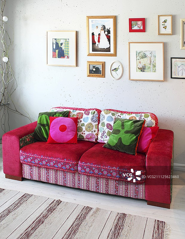 浪漫的混合图案的红色沙发下面的相框的图片在墙上图片素材