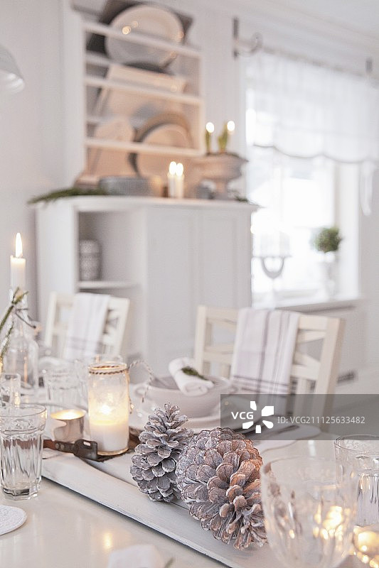 彩绘松果和蜡烛摆放在喜庆的餐桌上图片素材