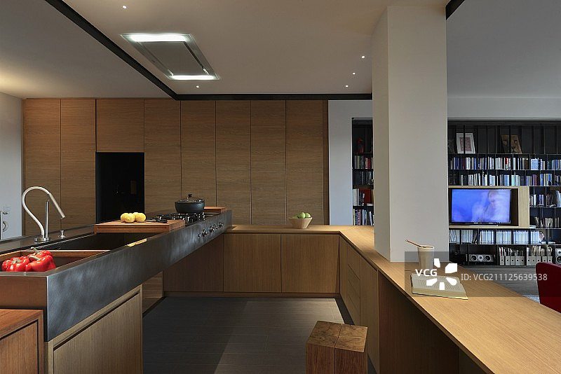 开放式，木质设计师厨房与金属水槽和一体化支柱;生活区的架子视图图片素材