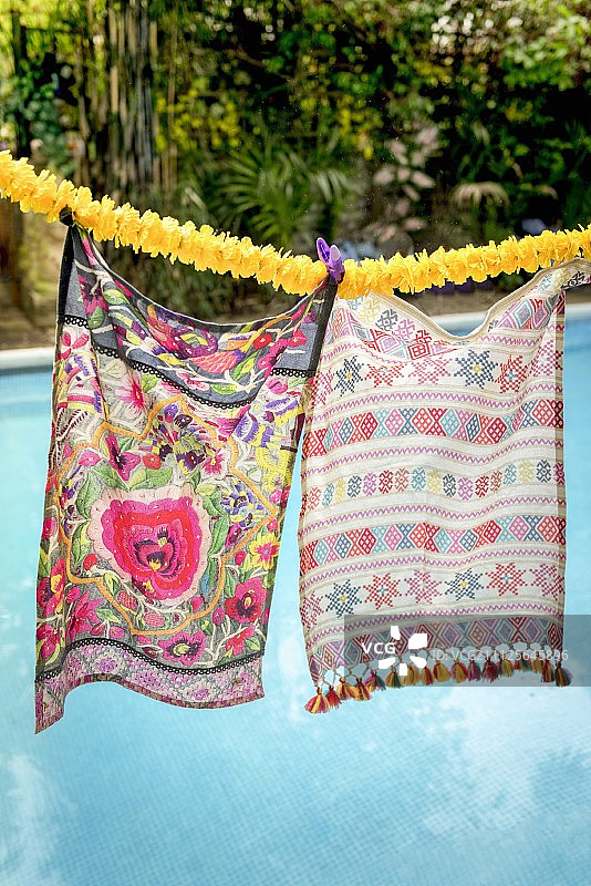 泳池上方的花环上挂着图案鲜艳的围巾图片素材