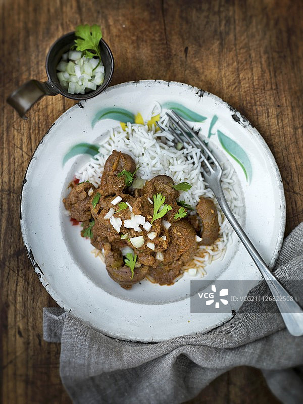 印度腰子咖喱，切碎的洋葱和香菜，铺在米饭上图片素材