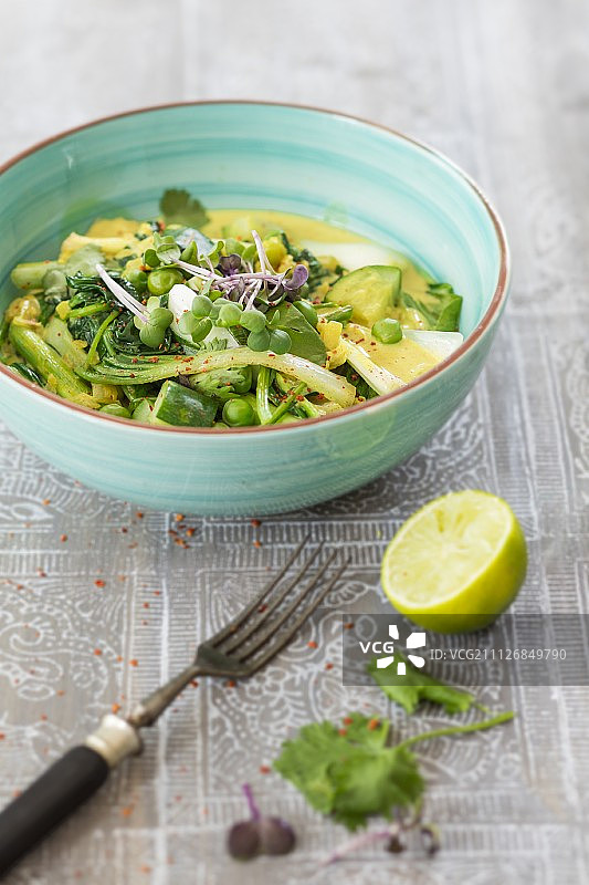 淡蓝色碗里的绿色蔬菜咖喱图片素材