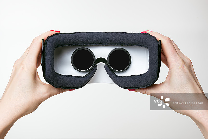 女性手握虚拟现实眼镜，VR，白色背景图片素材