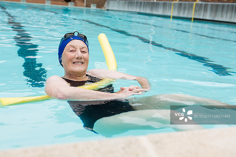 老年妇女在休闲中心的游泳池游泳图片素材