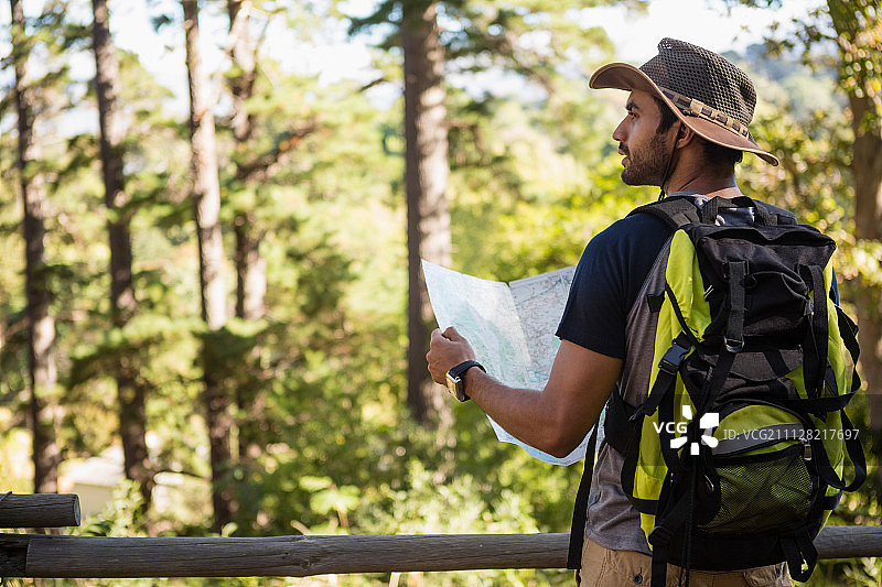 一个人拿着地图，在森林里看远方图片素材