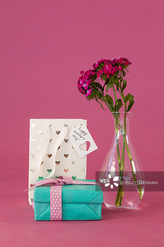 礼品盒，纸袋和花瓶在粉红色的背景图片素材