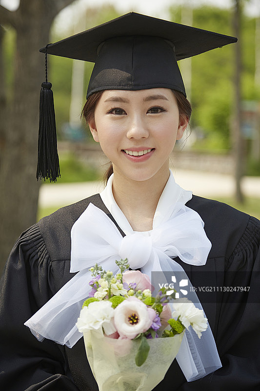 女人拿着毕业服装捧着花束图片素材