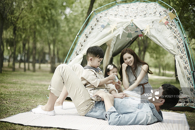 快乐的家庭在露营旅行，父亲和他的孩子玩图片素材