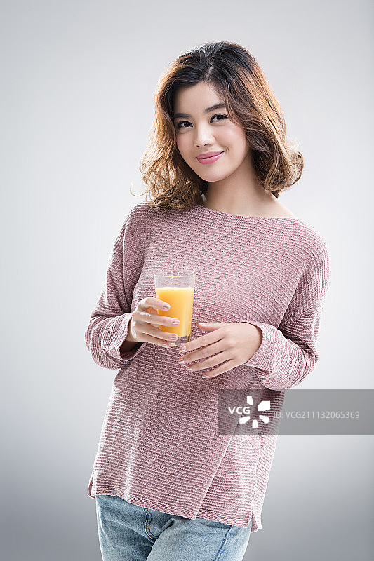 年轻美女喝橙汁图片素材