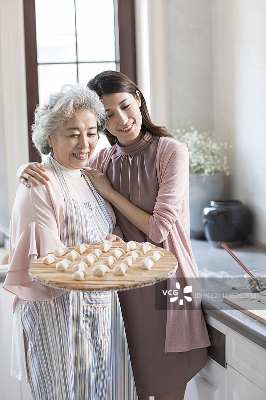 快乐的母女俩在厨房包饺子图片素材
