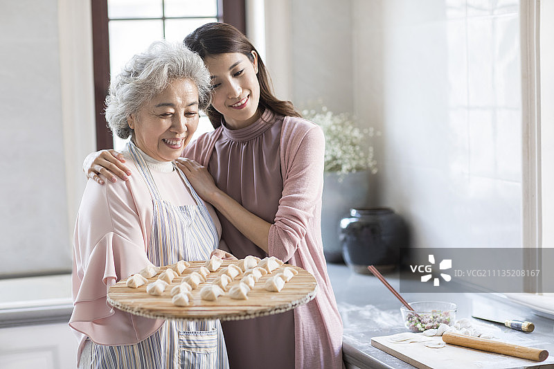 快乐的母女俩在厨房包饺子图片素材