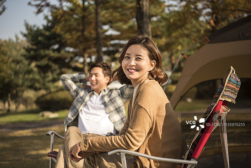 一对夫妇在秋天坐在公园的躺椅上野餐的照片图片素材